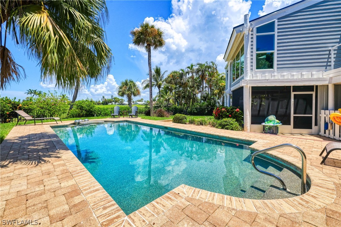 1021 Sand Castle Road Sanibel, FL 33957 - Photo 8 of 49 a view of swimming pool with a garden and patio