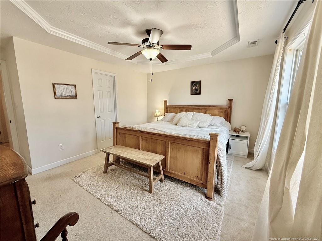 234 Pender Road Spring Lake, NC 28390 - Photo 28 of 39 a bedroom with a bed and a chandelier