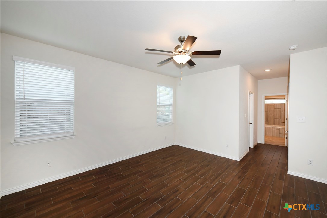 2069 Flametree Avenue New Braunfels, TX 78132 - Photo 21 of 46 a view of a big room with wooden floor and a ceiling fan