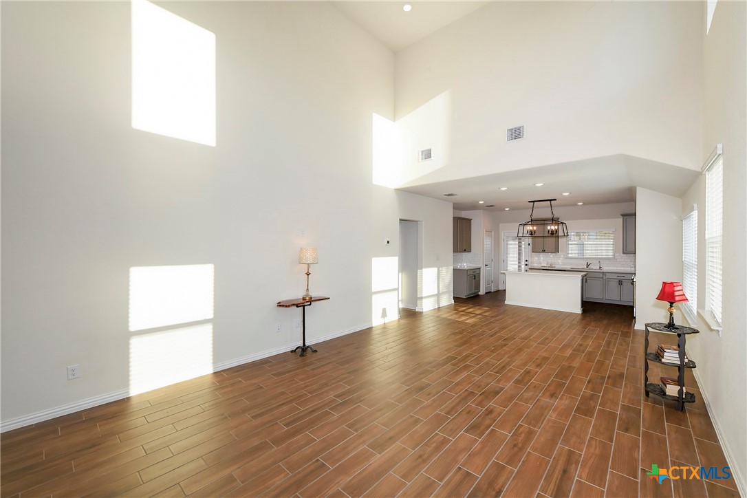 2069 Flametree Avenue New Braunfels, TX 78132 - Photo 8 of 46 an empty room with wooden floor and windows