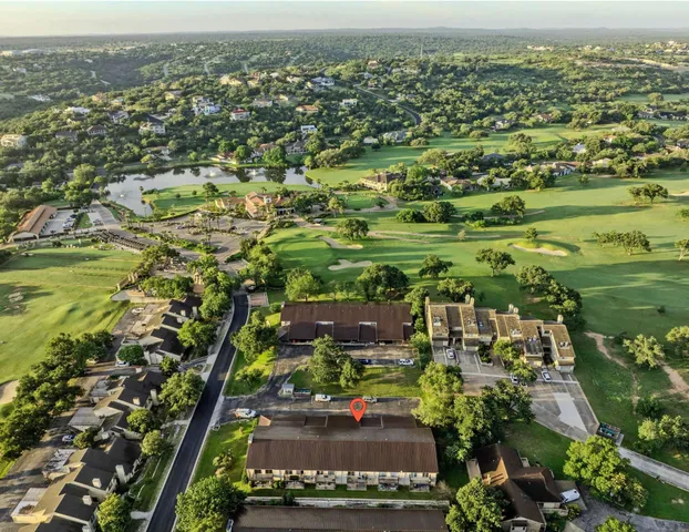 an aerial view of residential houses with outdoor space and trees