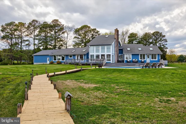 a view of a big house with a big yard and large trees