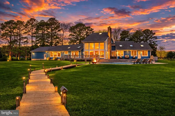 a view of a big house with a big yard and large trees