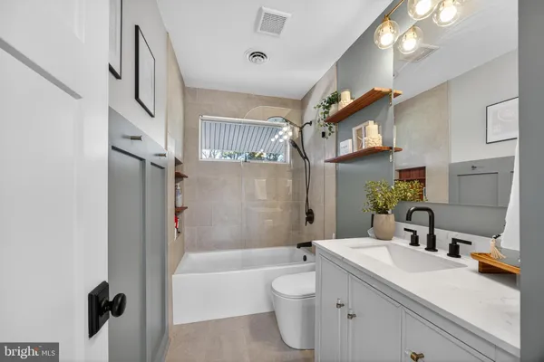 a bathroom with a tub sink and mirror