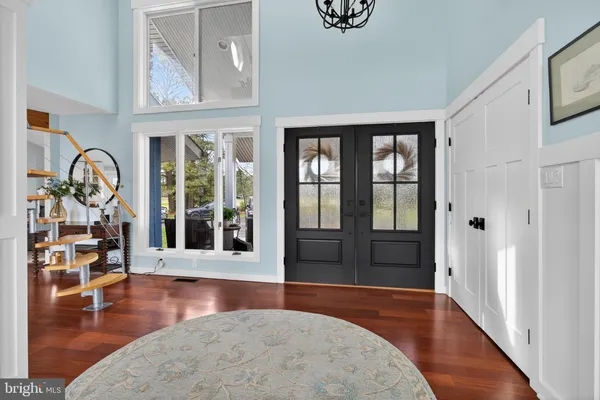 a living room with furniture large window and wooden floor