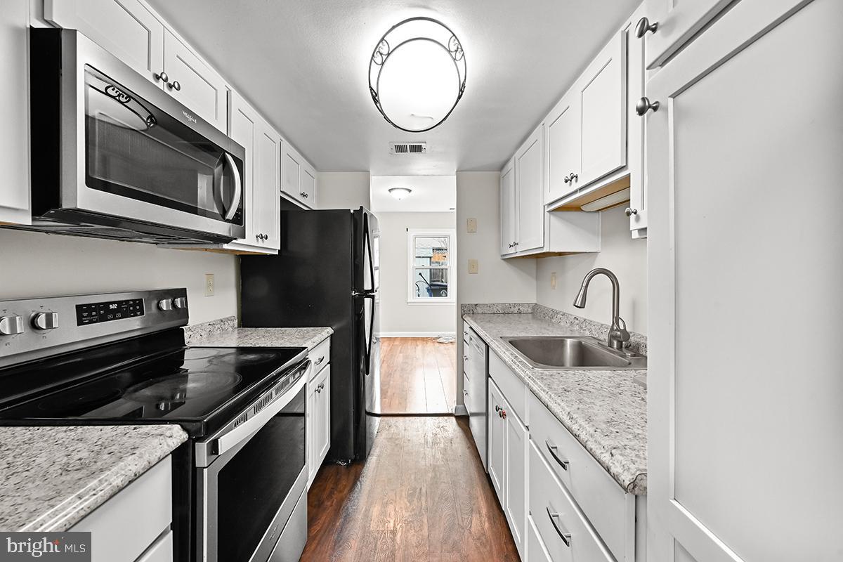 124 Marlow Street Southwest Leesburg, VA 20175 - Photo 7 of 37 a kitchen with stainless steel appliances granite countertop a sink a stove top oven and cabinetry