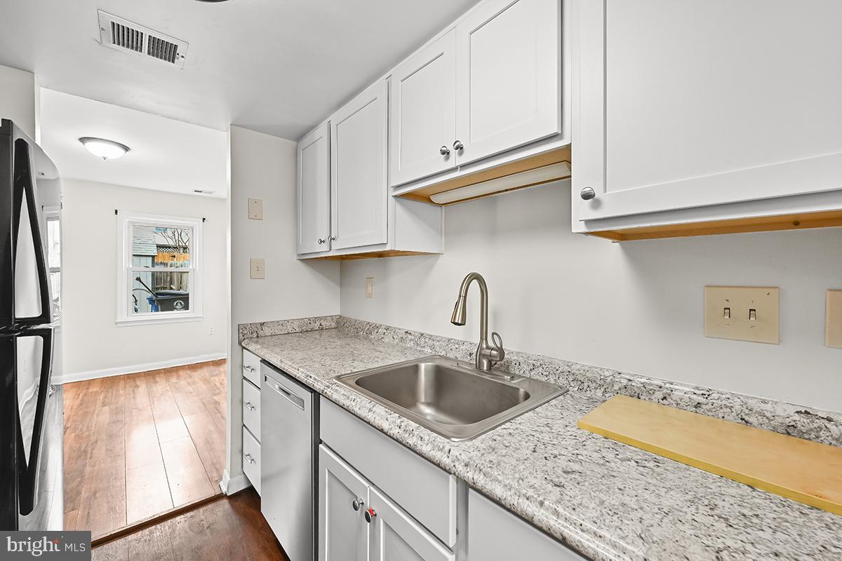 124 Marlow Street Southwest Leesburg, VA 20175 - Photo 8 of 37 a kitchen with stainless steel appliances granite countertop a sink dishwasher and cabinets with wooden floor