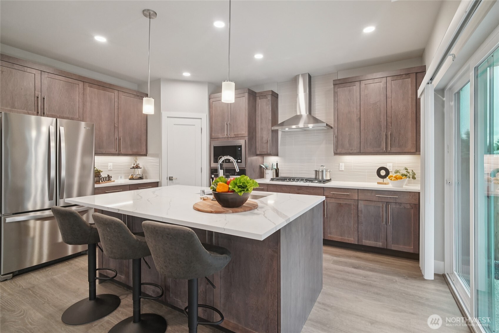 a kitchen with stainless steel appliances granite countertop a sink refrigerator and cabinets