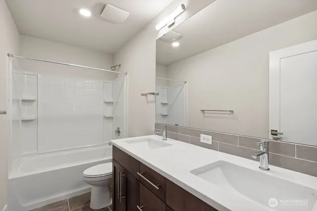 a bathroom with a sink a toilet a large mirror and shower