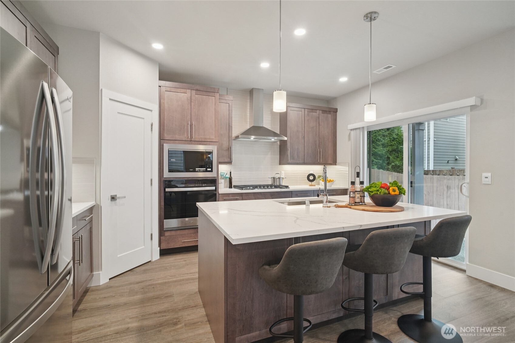 3822 194th Street Southeast Bothell, WA 98012 - Photo 4 of 29 a large kitchen with kitchen island a dining table and stainless steel appliances