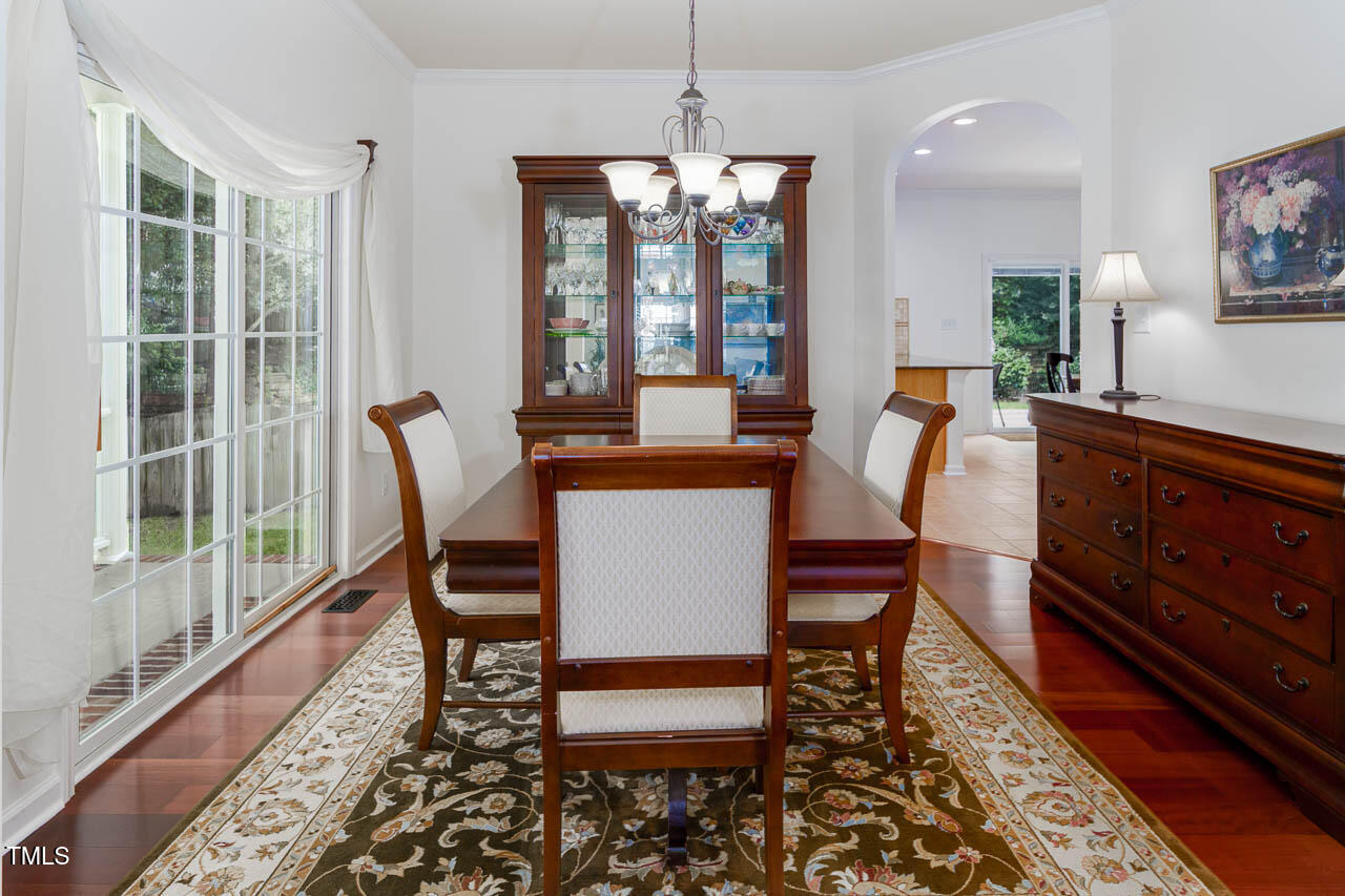 1059 Torrence Drive Apex, NC 27502 - Photo 14 of 49 a dining room with furniture a chandelier and wooden floor