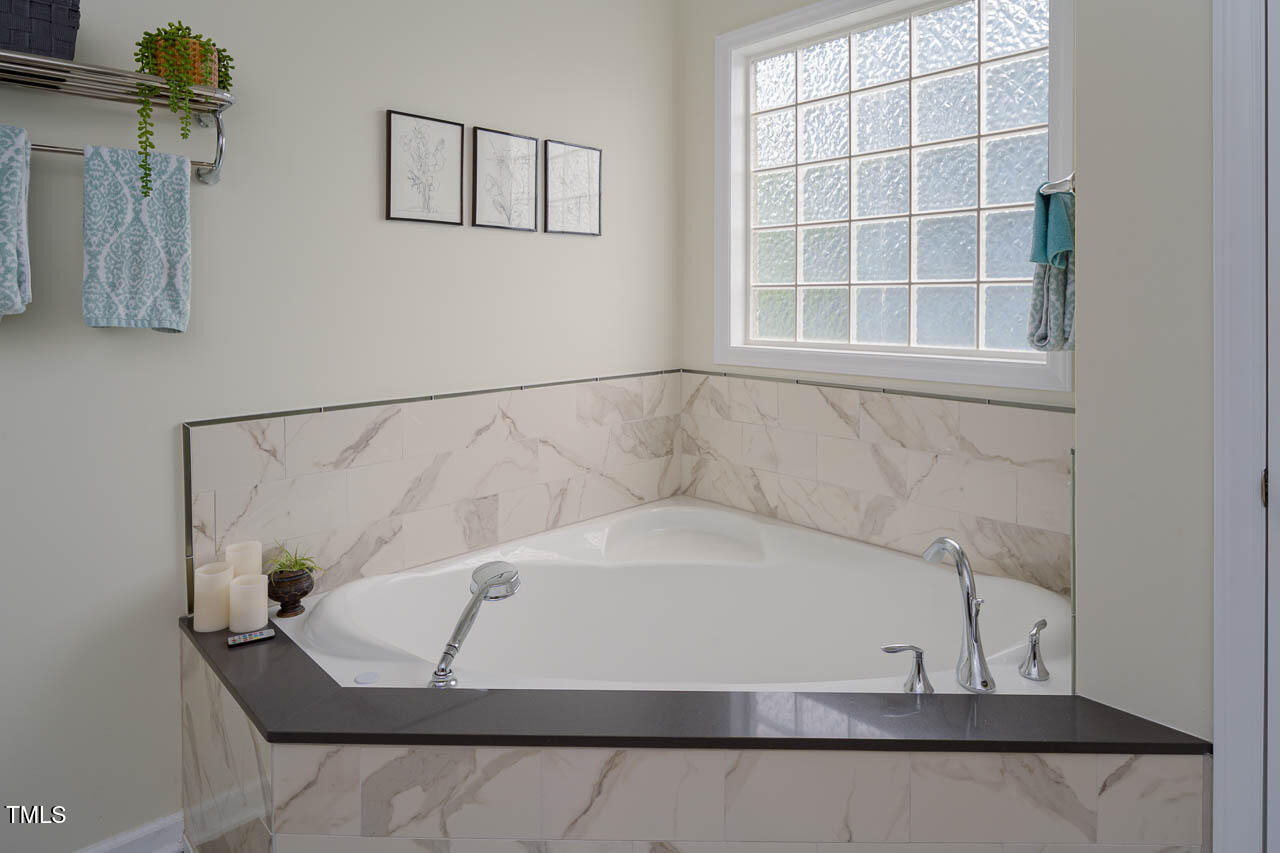 1059 Torrence Drive Apex, NC 27502 - Photo 21 of 49 a white bath tub sitting in a bathroom next to a window