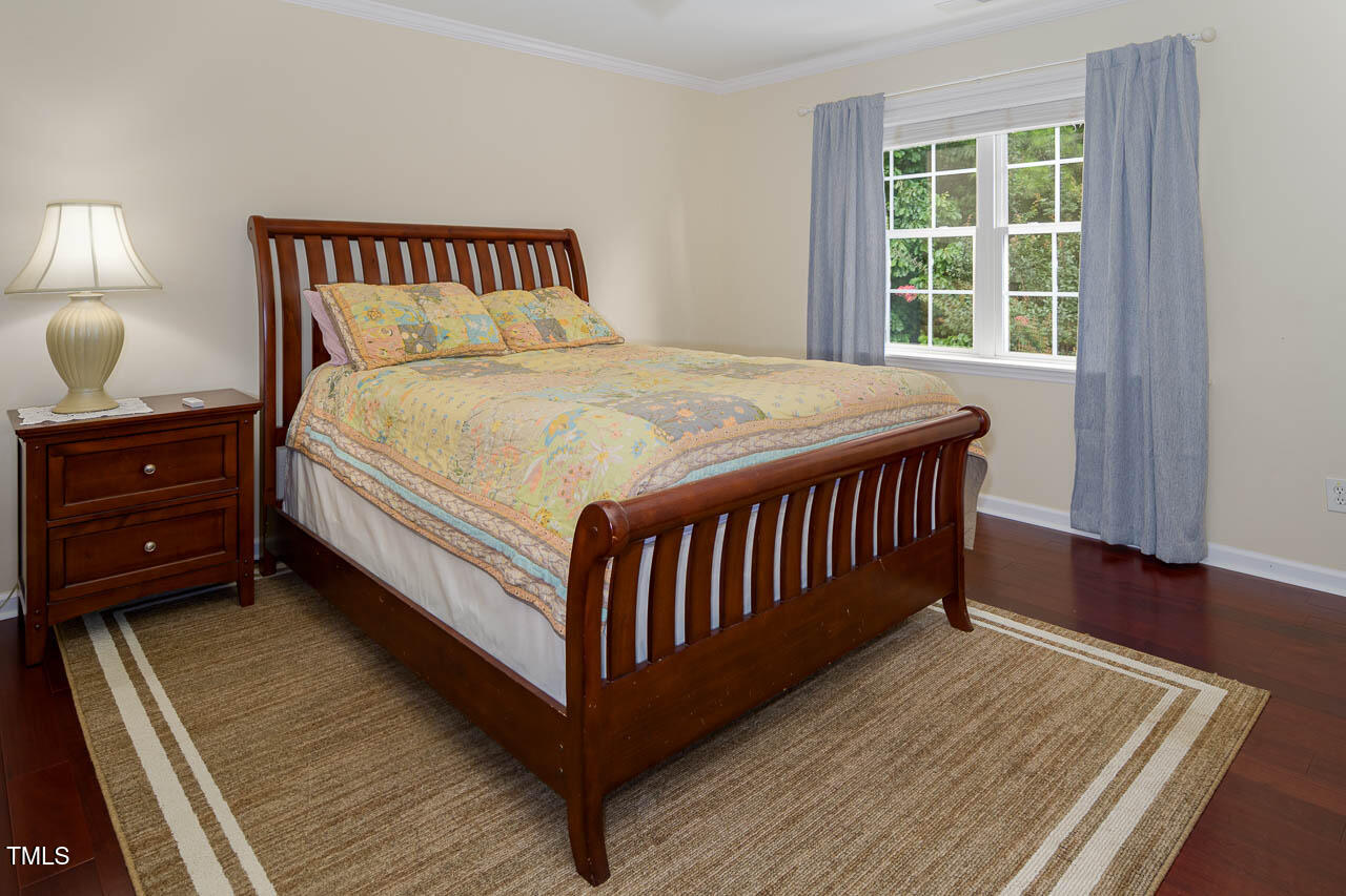 1059 Torrence Drive Apex, NC 27502 - Photo 26 of 49 a bed sitting in a bedroom next to a window with wooden floor