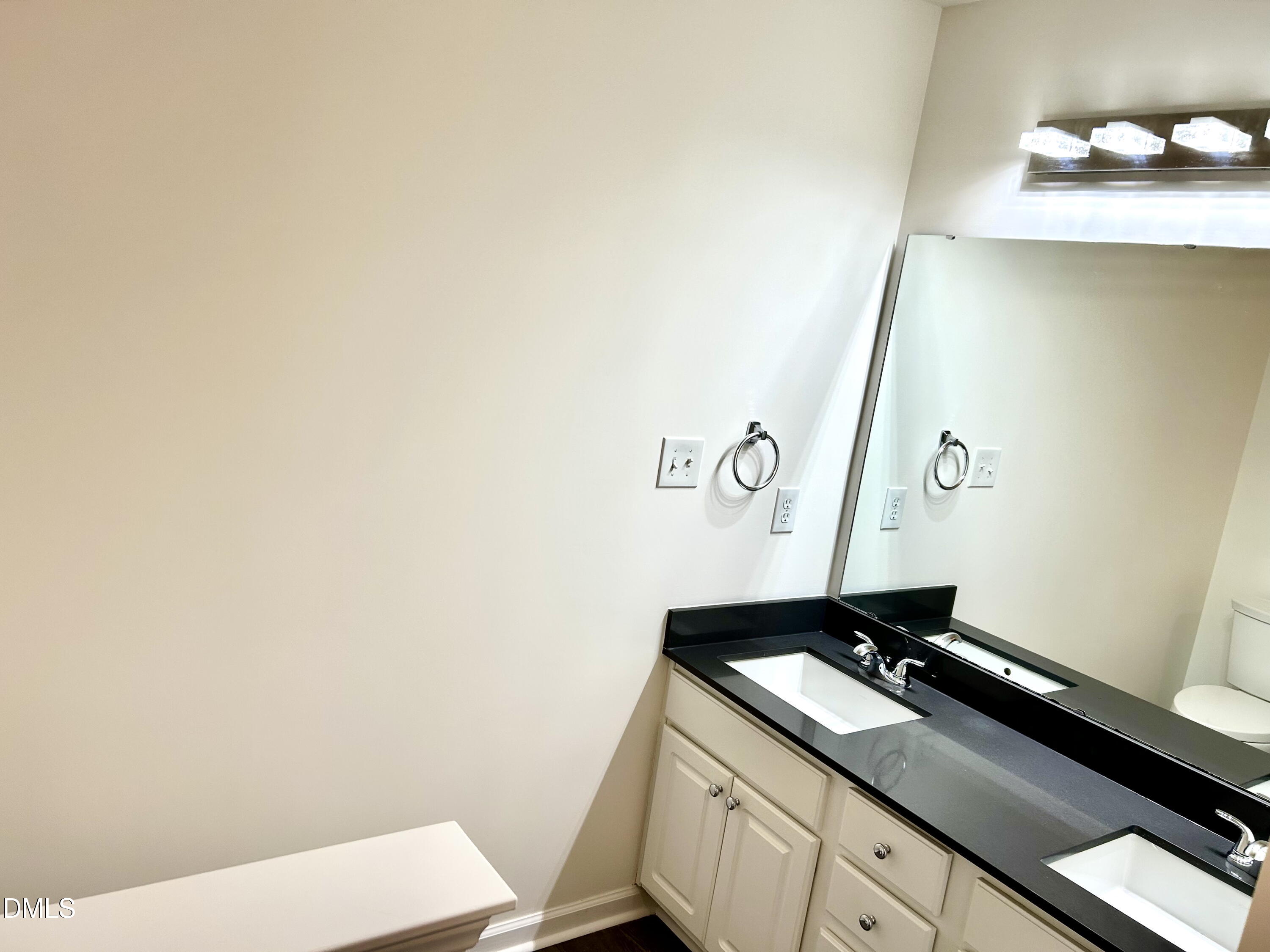 1059 Torrence Drive Apex, NC 27502 - Photo 30 of 49 a bathroom with a granite countertop sink and a mirror