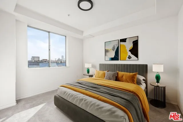 a bedroom with a bed and painting on the wall