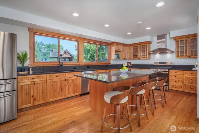 a kitchen with stainless steel appliances granite countertop a stove a sink and a refrigerator