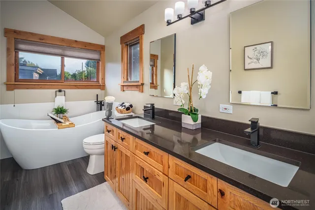 a bathroom with a granite countertop sink mirror vanity and toilet
