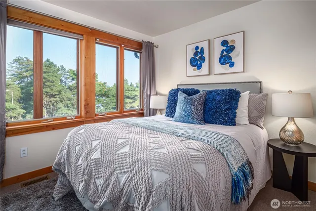 a bedroom with a bed and a large window