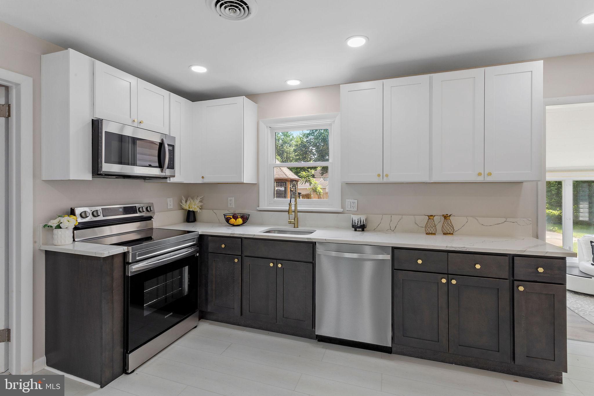 a kitchen with stainless steel appliances granite countertop a stove sink microwave and cabinets