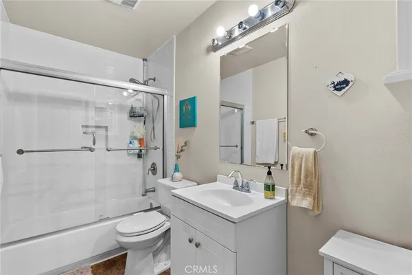 a bathroom with a sink a toilet a mirror and shower