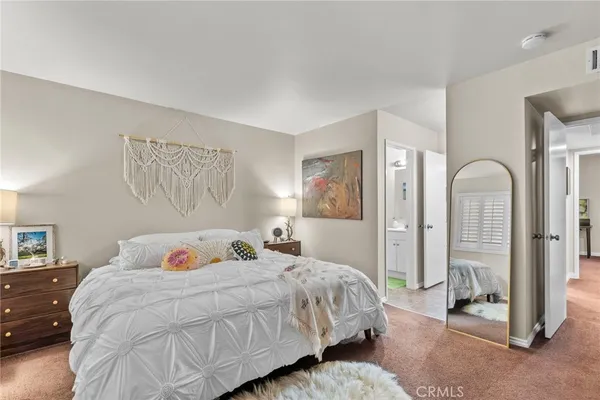 a bedroom with a bed and a painting on the wall