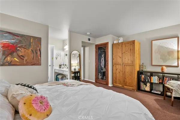 a spacious bedroom with a bed and a chandelier
