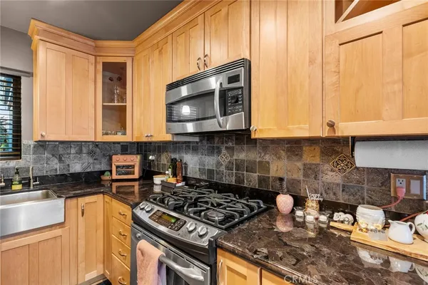 a kitchen with stainless steel appliances granite countertop a stove a microwave and cabinets