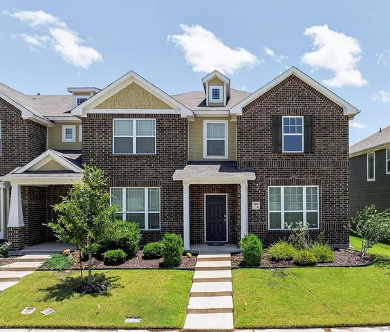 a front view of a house with yard and green space