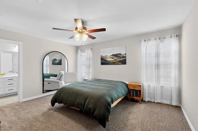 a spacious bedroom with a bed a dresser and a window