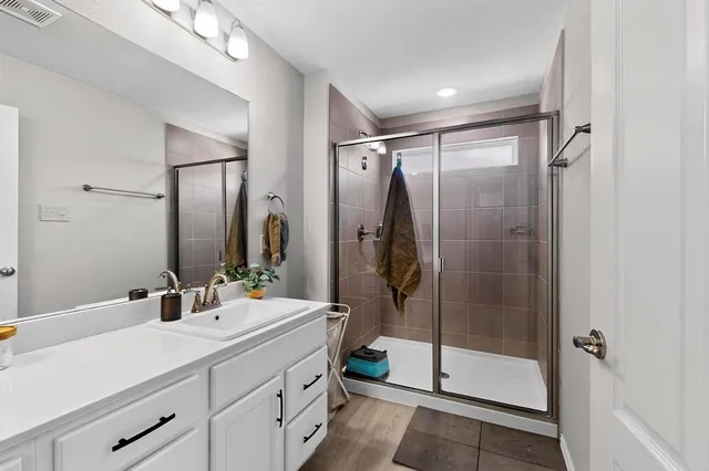 a bathroom with a shower sink and mirror