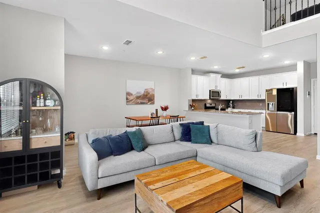 a living room with furniture and a view of kitchen appliances