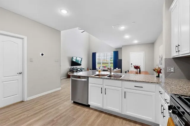 a kitchen with stainless steel appliances granite countertop a sink stove and refrigerator
