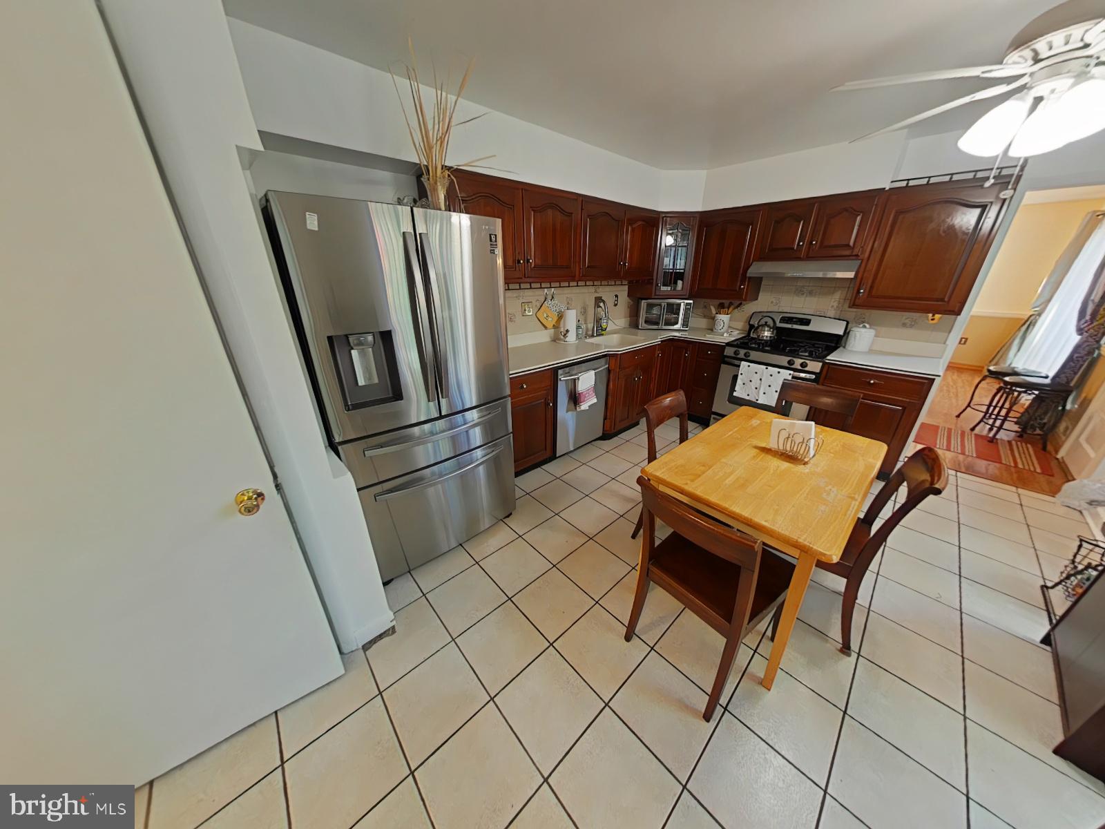 12807 Crisfield Road Silver Spring, MD 20906 - Photo 2 of 30 a kitchen with a refrigerator a stove top oven and sink