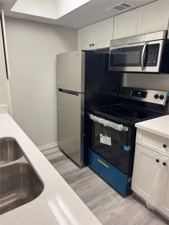 a kitchen with granite countertop a refrigerator stove and microwave