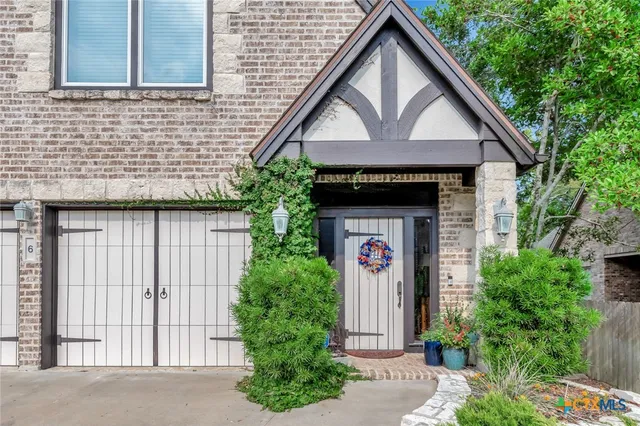a front view of a house with plants
