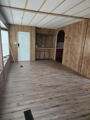 a view of an empty room with closet and a window