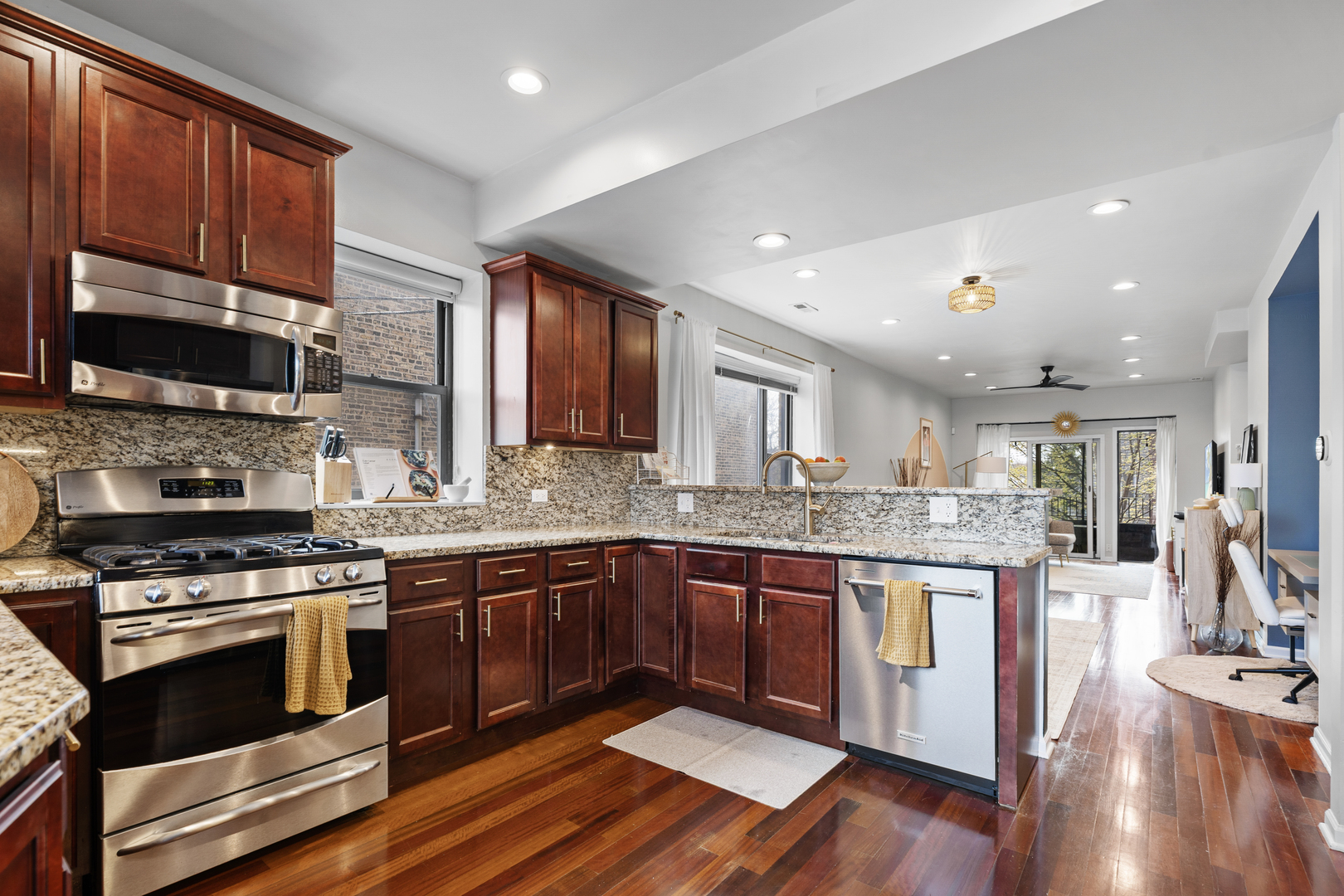 3918 West Roscoe Street, Unit 2 Chicago, IL 60618 - Photo 7 of 19 a kitchen with stainless steel appliances granite countertop wooden floor a stove cabinets a sink and a counter space