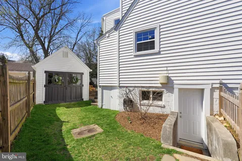 a view of a house with a yard and a large tree