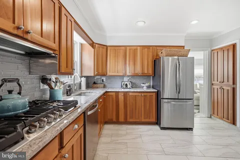 a kitchen with stainless steel appliances granite countertop a refrigerator stove and sink