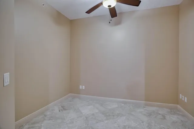 an empty room with a ceiling fan and hardwood floor
