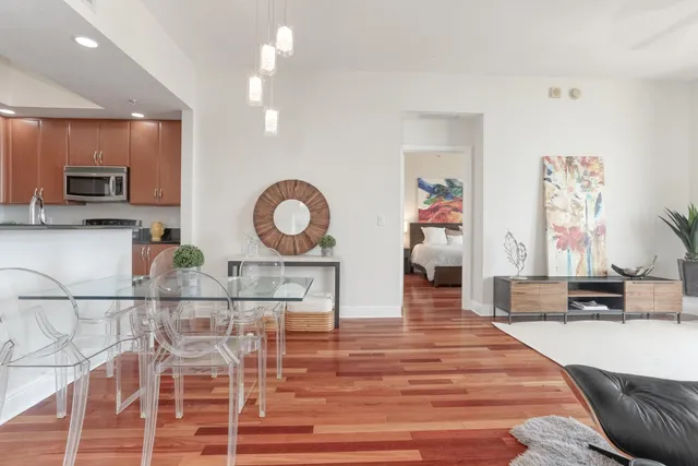 a living room with furniture a flat screen tv and kitchen view