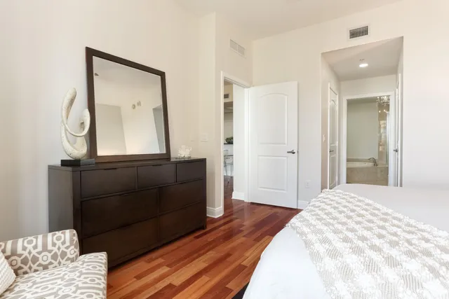 a bedroom with a bed and a mirror on dresser