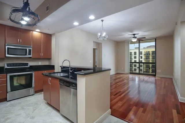 a kitchen with stainless steel appliances granite countertop a stove and a wooden floors