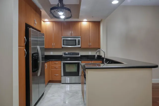 a kitchen with stainless steel appliances a sink stove and refrigerator