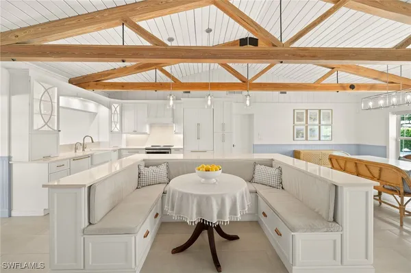 a kitchen with a sink a stove and white cabinets with wooden floor