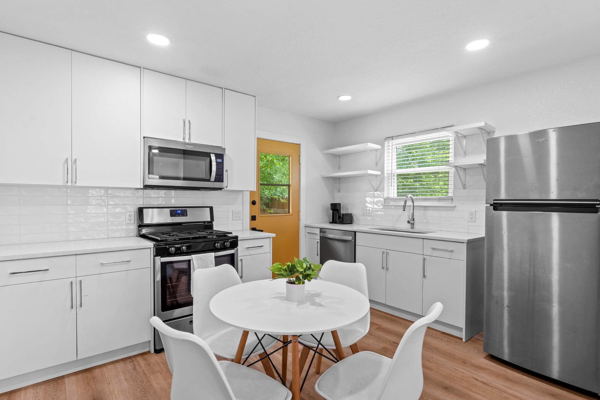 10601 Macmora Road, Unit B Austin, TX 78758 - Photo 8 of 22 A well-lit kitchen presents bright white cabinetry paired with modern stainless steel appliances.