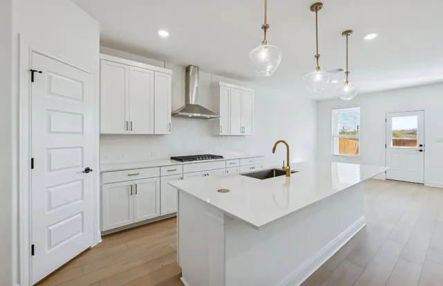 a kitchen with white cabinets and sink