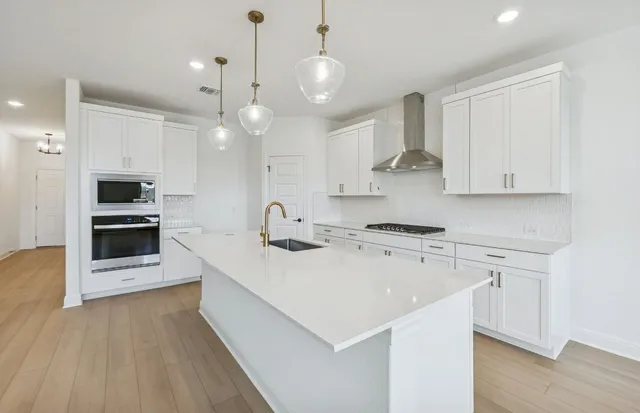 a kitchen with stainless steel appliances sink stove and cabinets