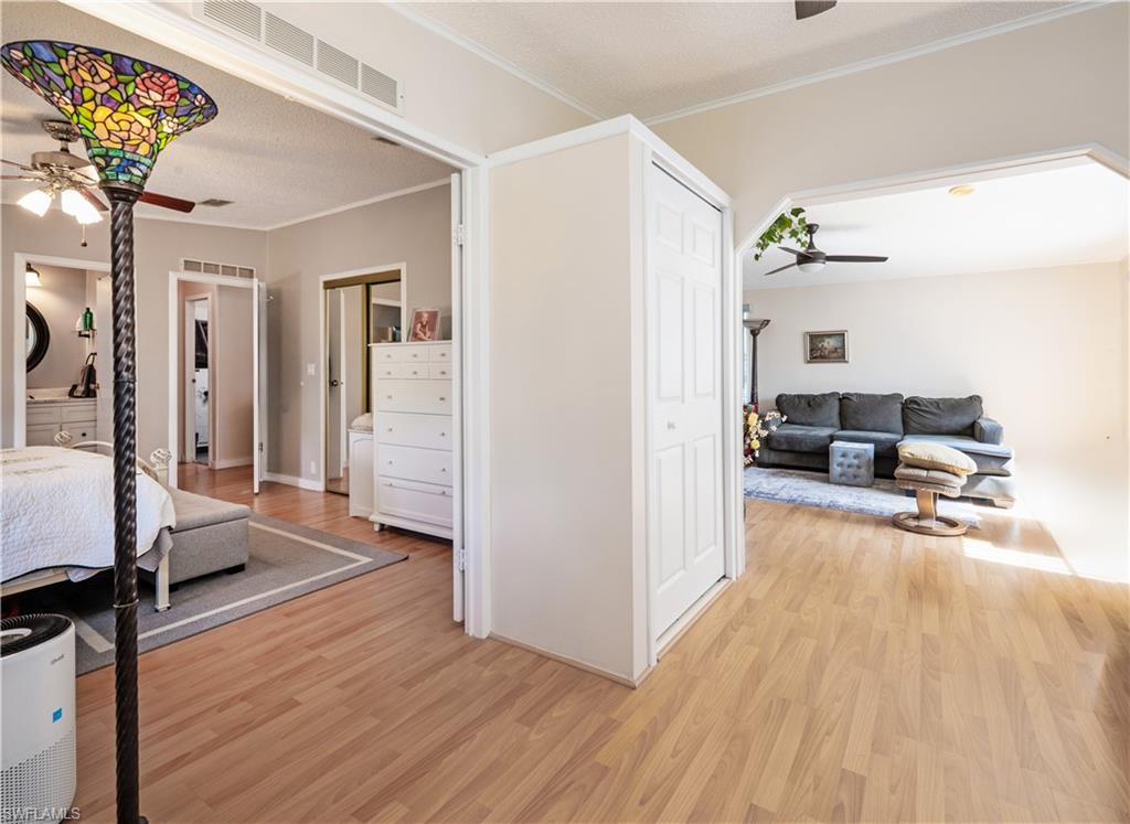 308 Riverwood Road Naples, FL 34114 - Photo 21 of 22 Bedroom with light wood-type flooring, crown molding, and a ceiling fan