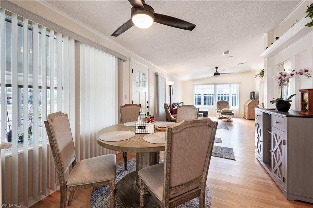 308 Riverwood Road Naples, FL 34114 - Photo 8 of 22 Dining area with ceiling fan, a textured ceiling, ornamental molding, and light wood-style floors